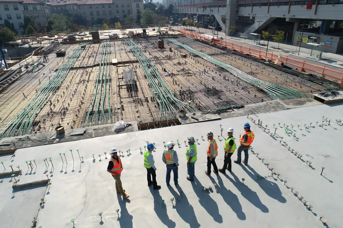 Equipe de capacete e colete em visita técnica a canteiro de obras