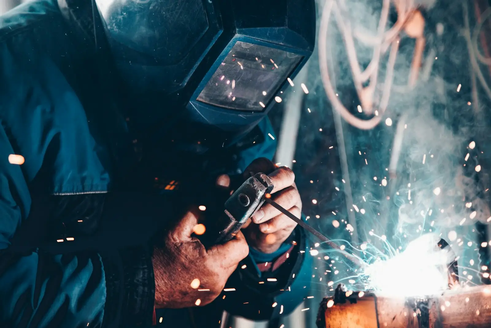 Trabalhadores de capacete e colete em ambiente industrial